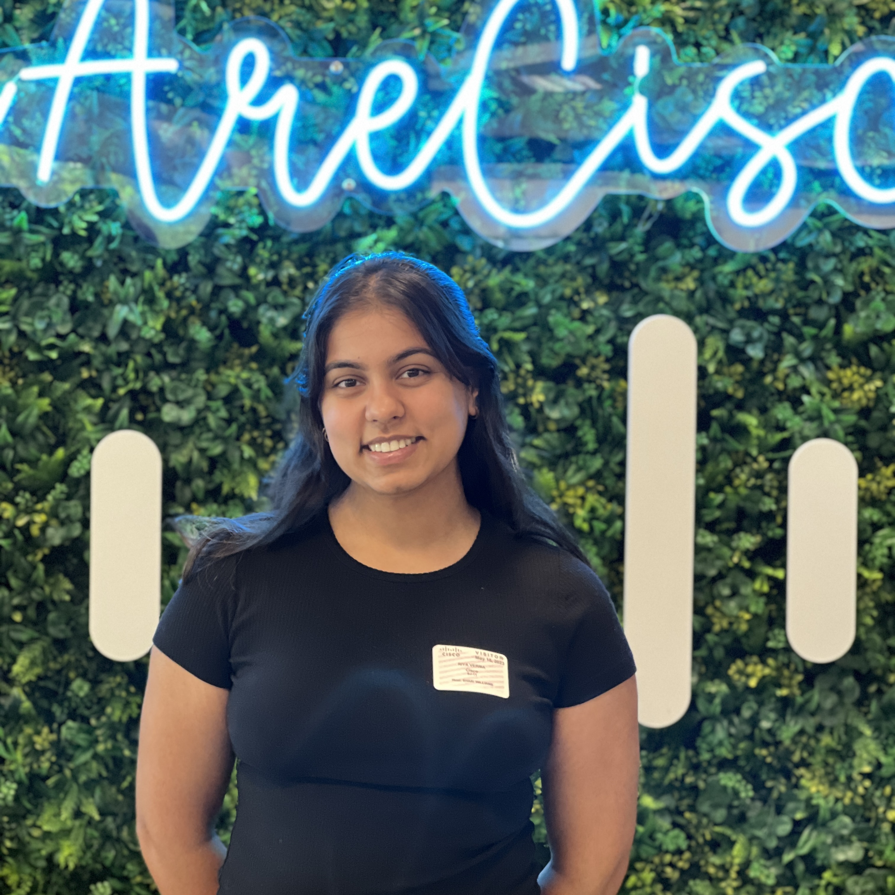 Picture of Riya in front of Cisco logo
